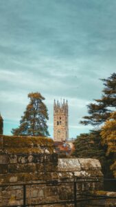 Stone tower of St Mary's Church in an autumn setting with trees.