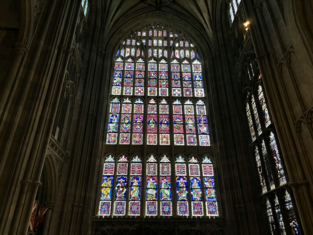 Stunning stained glass window in Canterbury Cathedral, showcasing intricate designs and vibrant colors.